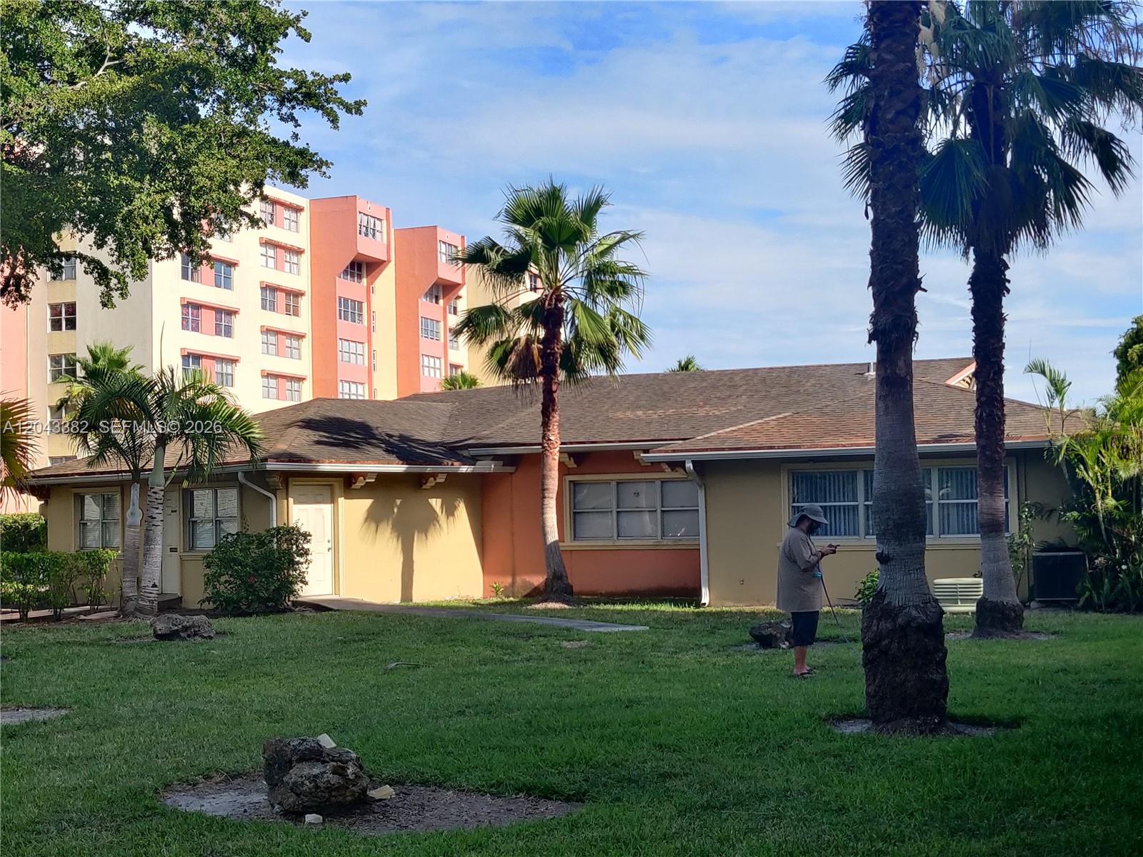 A single-story house with a lawn, palm trees, and a tall apartment building behind it — 9001 SW 77th Ave # C606, Miami FL 33156, MIAMI, FL