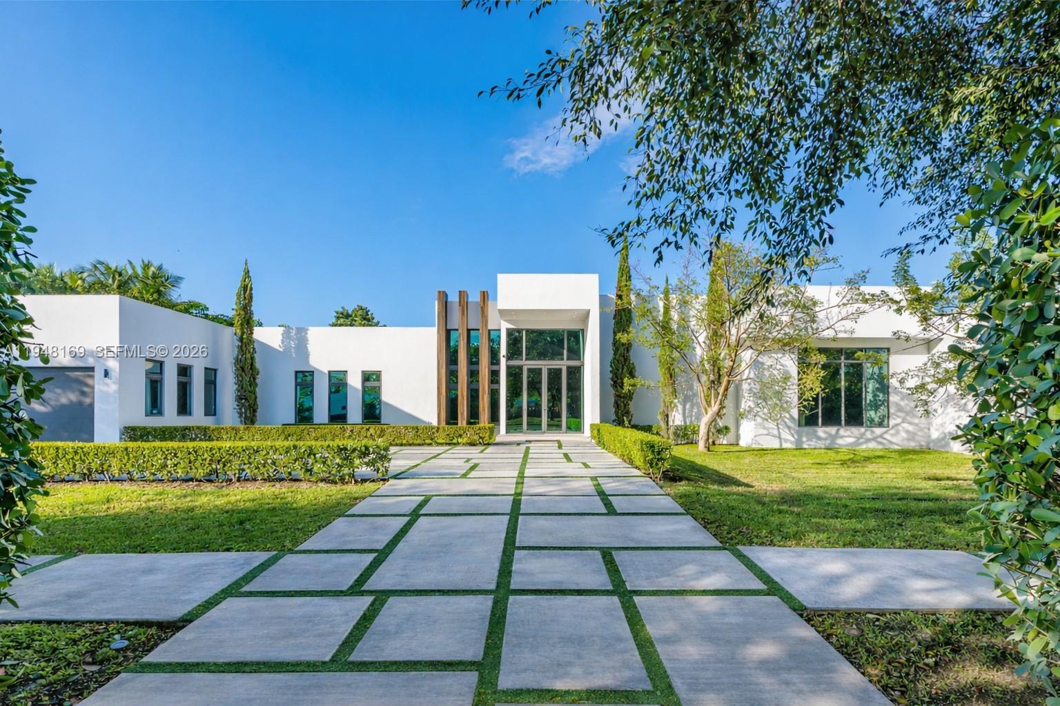 A modern white house features a geometric concrete walkway leading to a glass entryway — 6175 SW 128th Street, Pinecrest FL 33156, PINECREST, FL