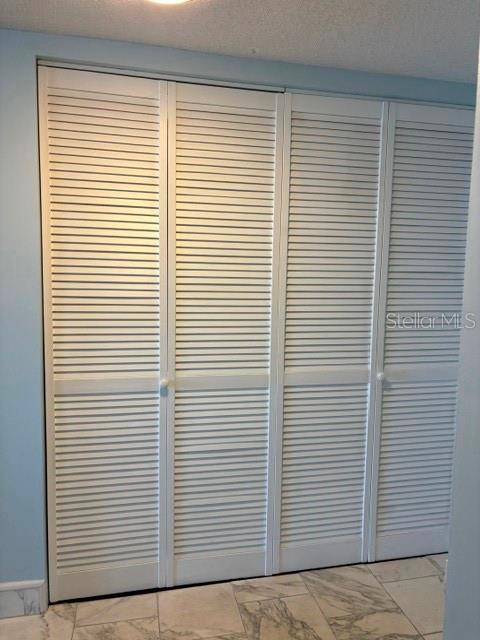 A set of white louvered bifold closet doors installed in a room with tiled flooring — 7920 SUN ISLAND DRIVE S UNIT 205, SOUTH PASADENA, FL