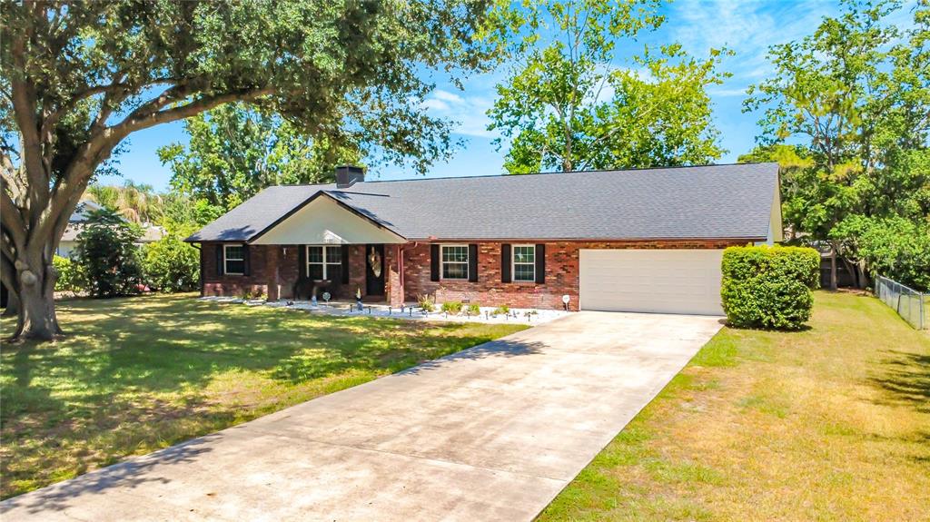 A single-story brick house with a gray shingled roof and a concrete driveway — 5501 SE 42ND COURT, OCALA, FL