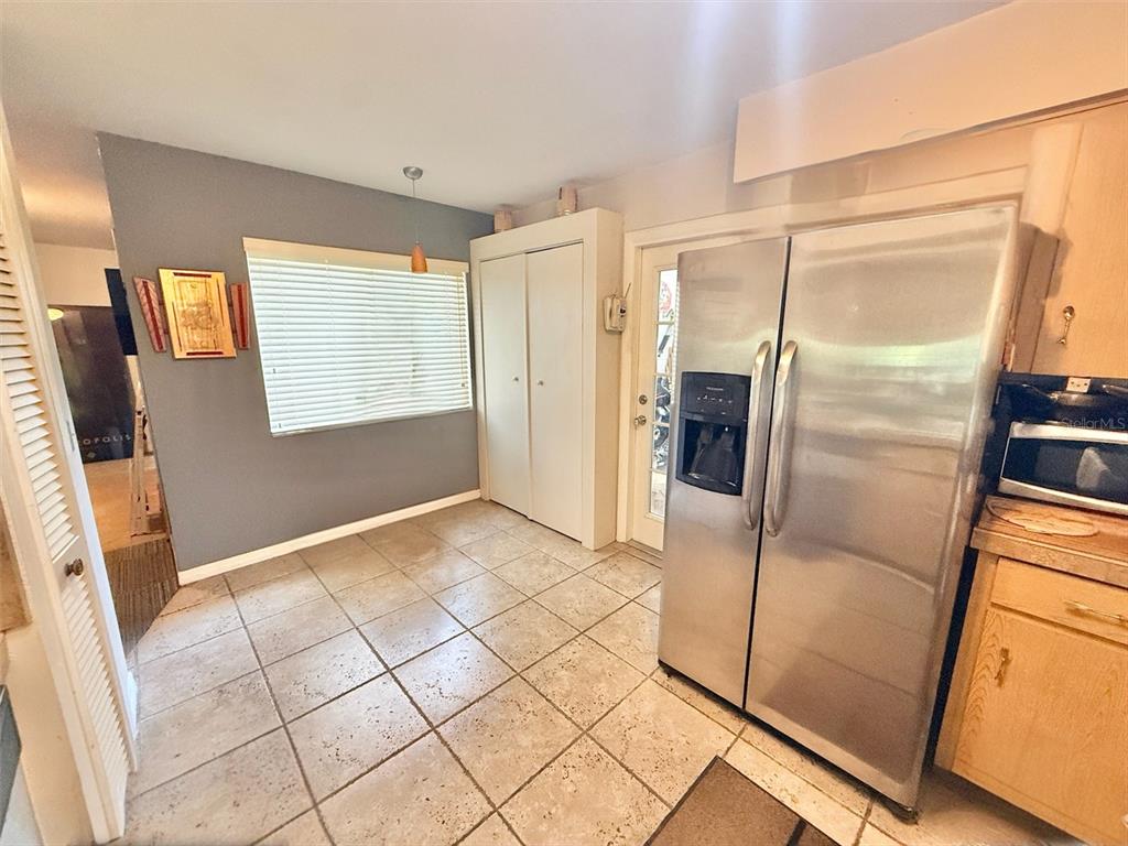 A kitchen with tile flooring, a stainless steel refrigerator, and a window with blinds — 7137 MARVISTA COURT, ORLANDO, FL