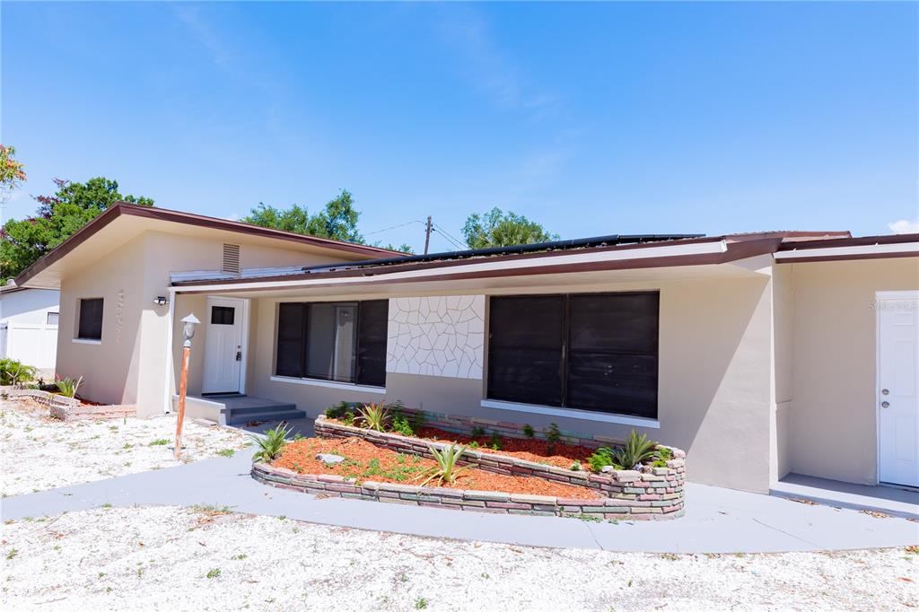 A single-story house exterior features a stone planter, white trim, and a flat roof — 4946 DR MARTIN LUTHER KING JR STREET S, ST PETERSBURG, FL