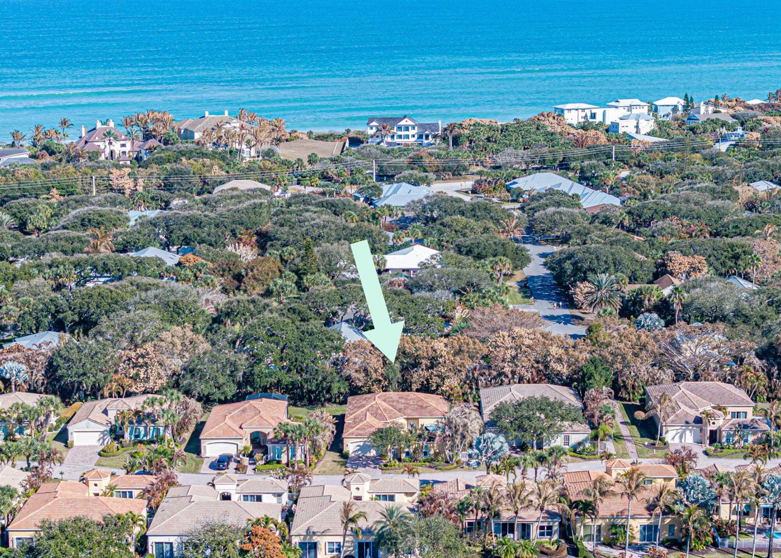 An aerial view shows a residential neighborhood with houses surrounded by trees near the ocean — 9630 E Maiden Court, Vero Beach FL 32963, VERO BEACH, FL