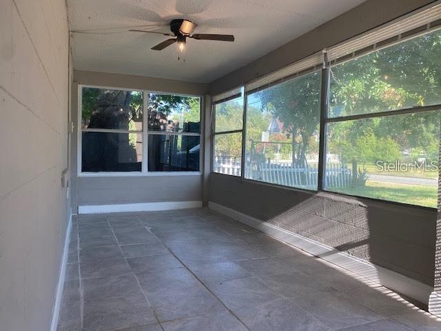 A sunroom with gray tiled floors, large windows, and a ceiling fan — 907 COLUMBIA STREET, ORLANDO, FL