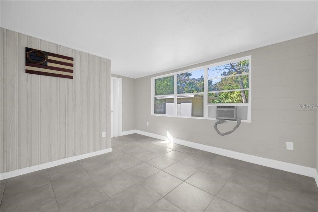 An empty room with gray tile flooring, light gray walls, and a window air conditioner — 907 COLUMBIA STREET, ORLANDO, FL