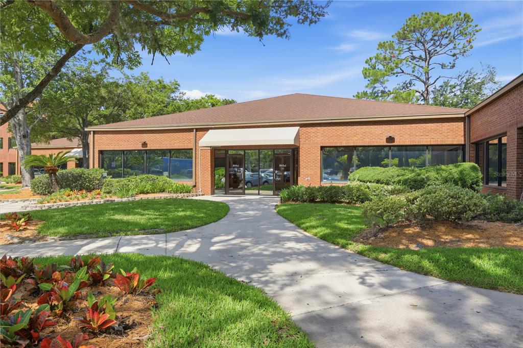 A single-story brick office building features a central glass entrance under a beige awning — 8669 BAYPINE ROAD, JACKSONVILLE, FL