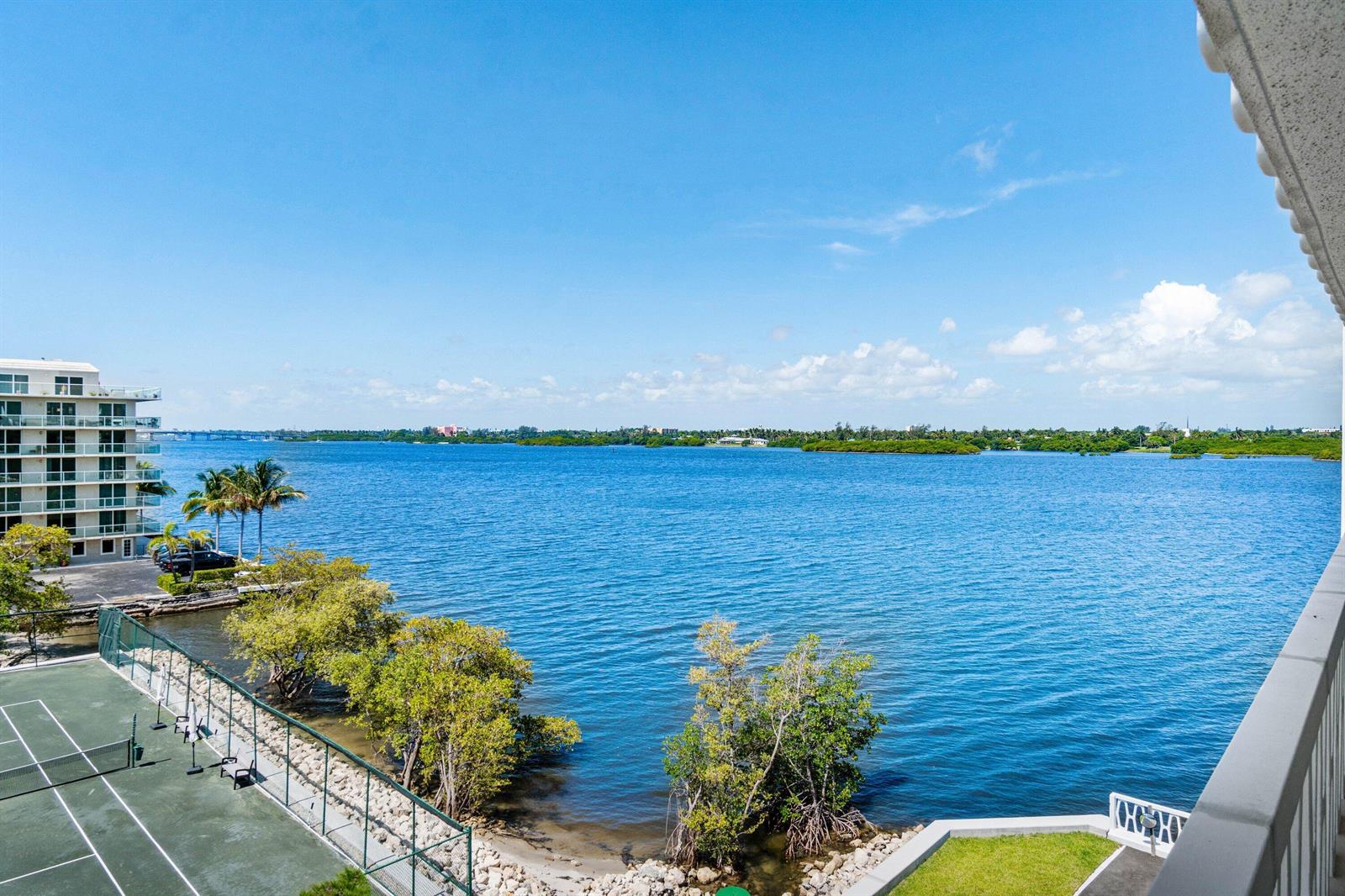 A high-angle view of a tennis court, waterfront, and a multi-story building under blue skies — 2505 S Ocean Boulevard # 515, Palm Beach FL 33480, PALM BEACH, FL