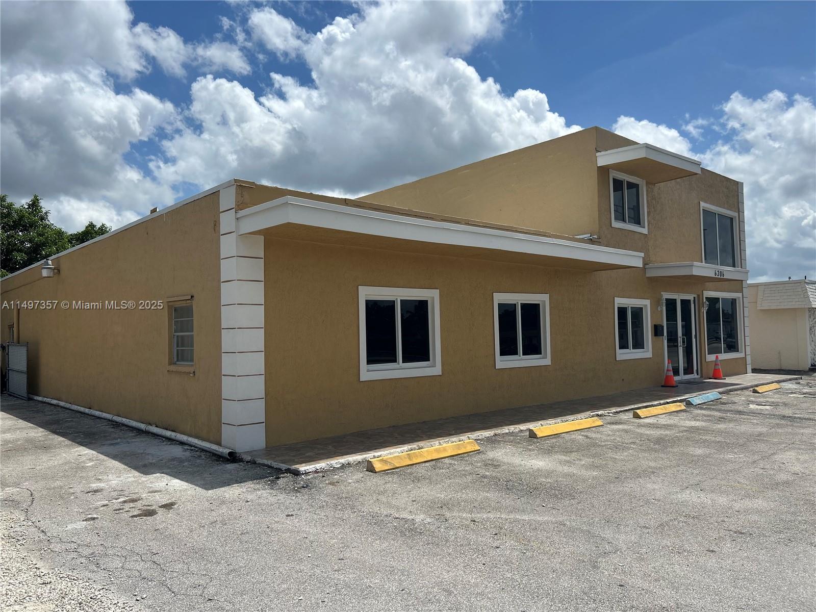 A two-story tan commercial building features a flat roof, white trim, and a paved parking lot — 6300 Pembroke Rd, Miramar FL 33023, MIRAMAR, FL