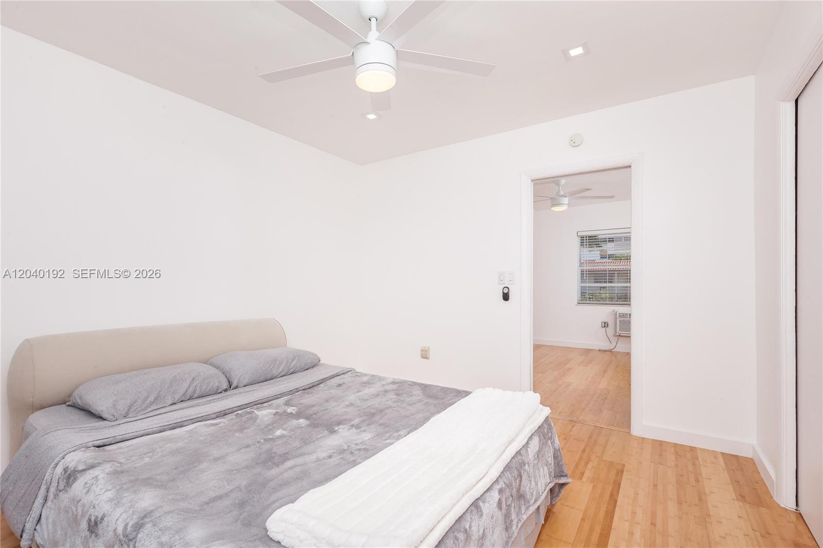 A bedroom with a bed, ceiling fan, and an open doorway to another room — 345 Michigan Ave # 20, Miami Beach FL 33139, MIAMI BEACH, FL