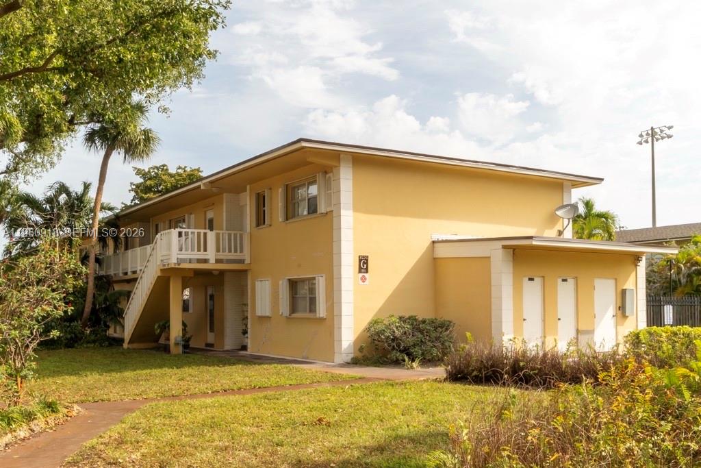 A two-story yellow apartment building features an exterior staircase and a ground-level storage area — 550 SE 2nd Ave # G25, Deerfield Beach FL 33441, DEERFIELD BEACH, FL