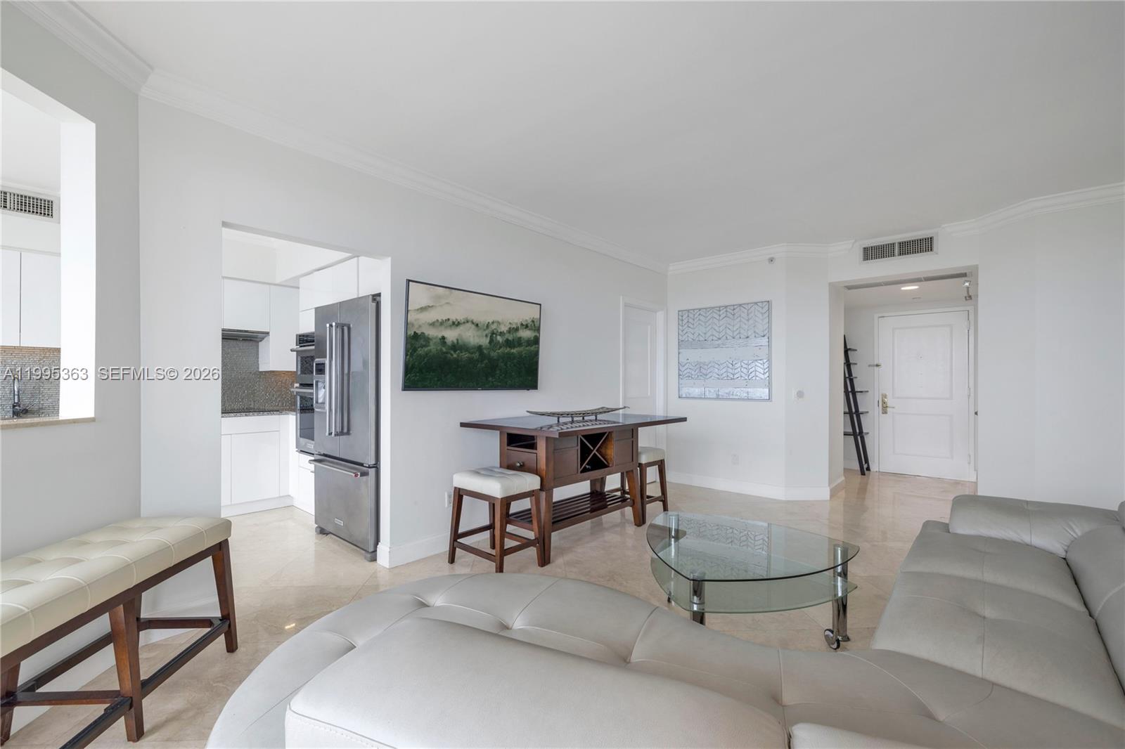 A living room with a sectional sofa, glass coffee table, and a small dining table — 4779 Collins Ave # 1706, Miami Beach FL 33140, MIAMI BEACH, FL