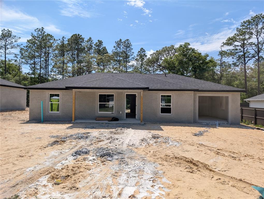 A galley kitchen features white cabinets, stainless steel appliances, and light wood-look flooring — 4258 SW 157TH COURT SW, OCALA, FL