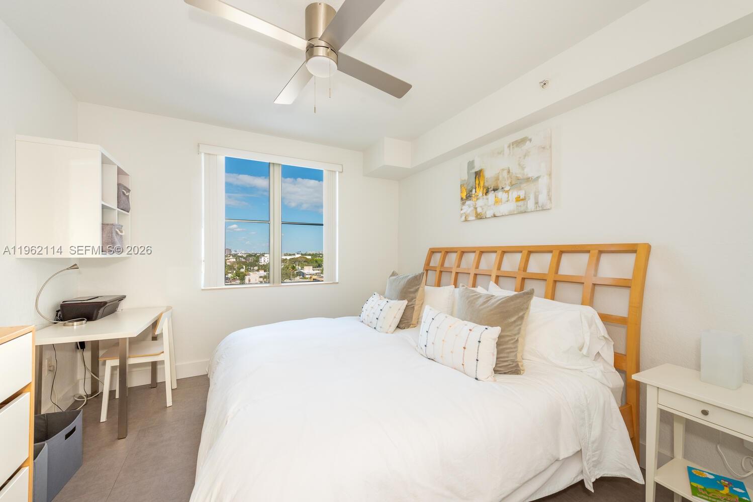 A bedroom features a bed with a wooden headboard, a desk, and a window view — 1830 Radius Dr # 709, Hollywood FL 33020, HOLLYWOOD, FL