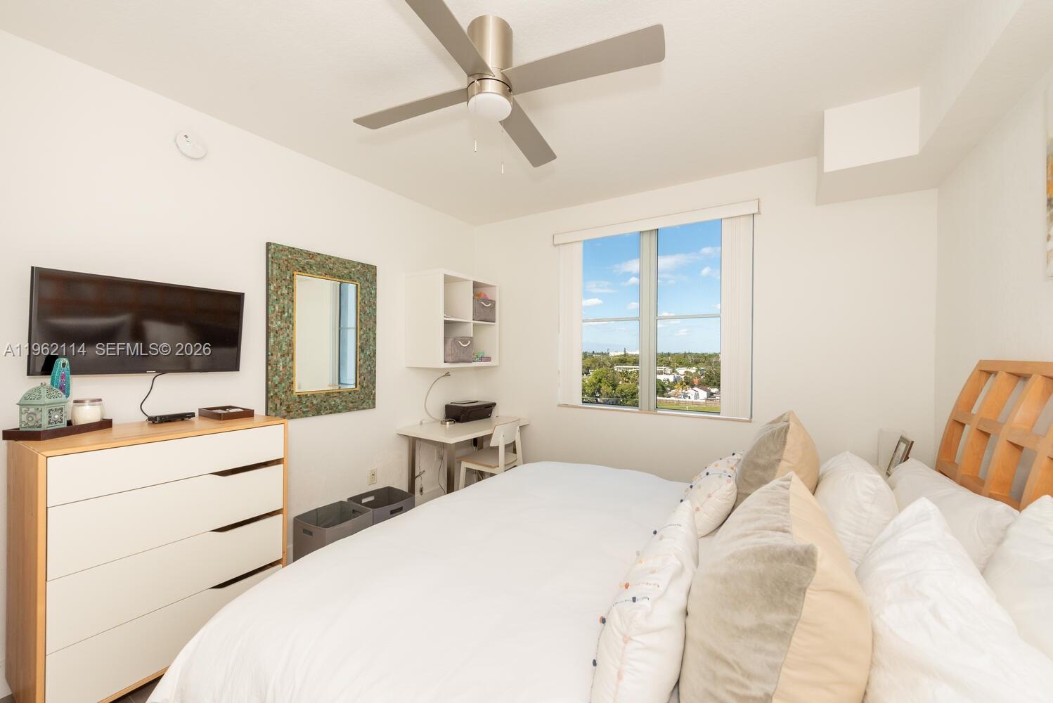 A bedroom features a bed, a dresser with a television, a desk, and a ceiling fan — 1830 Radius Dr # 709, Hollywood FL 33020, HOLLYWOOD, FL