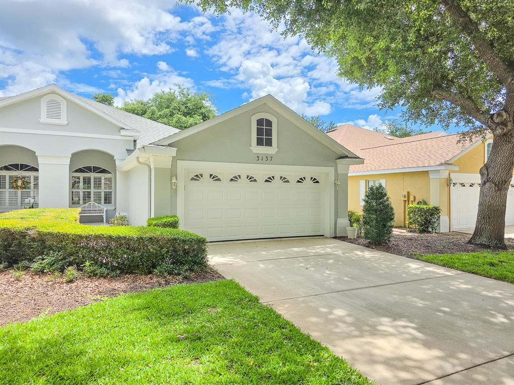 A single-story house with a white garage, light-colored stucco exterior, and a manicured lawn — 3137 KAILANI COURT, ORMOND BEACH, FL