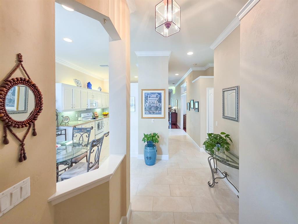 A view from a hallway looking into a kitchen with tile floors and neutral walls — 3137 KAILANI COURT, ORMOND BEACH, FL