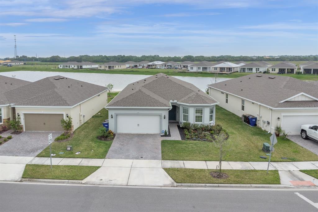 An aerial view of a single-story suburban house with a two-car garage and a pond — 2010 SPRING SHOWER CIRCLE, KISSIMMEE, FL