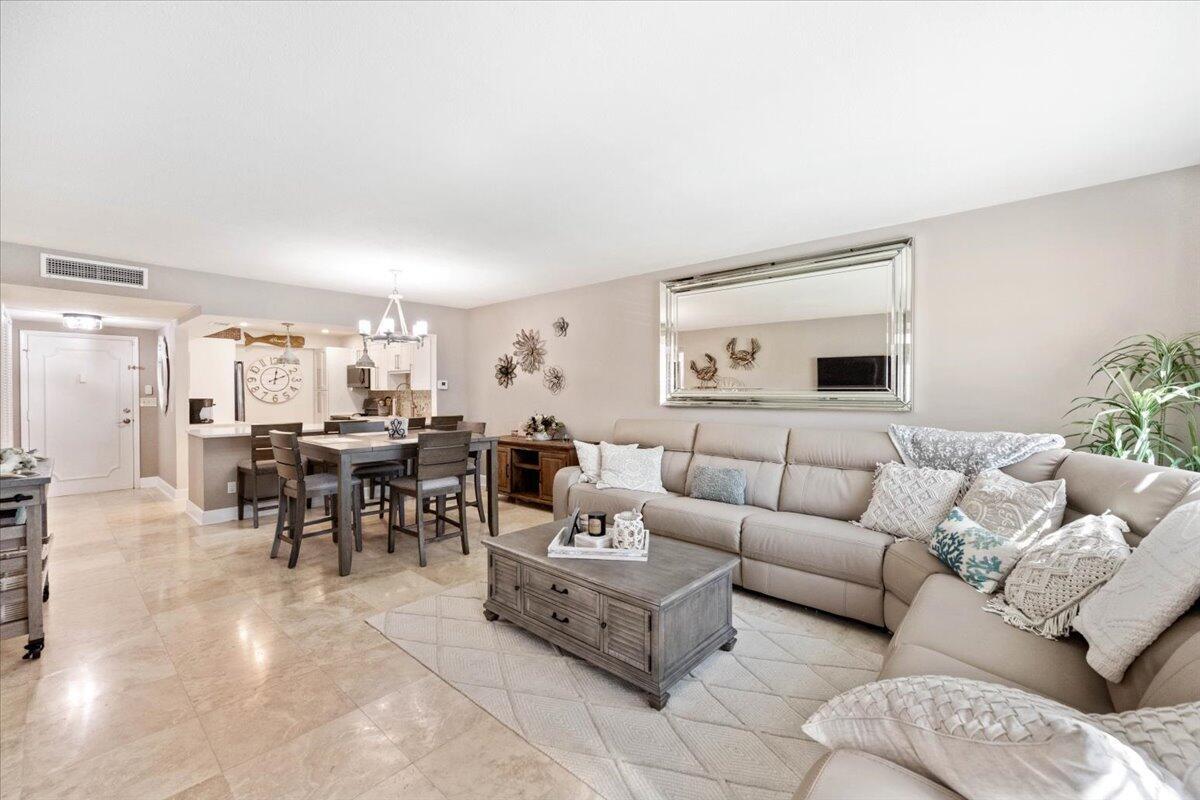 A living room and dining area with light tile floors, a sectional sofa, and furniture — 3475 S Ocean Boulevard # 1030, Palm Beach FL 33480, PALM BEACH, FL