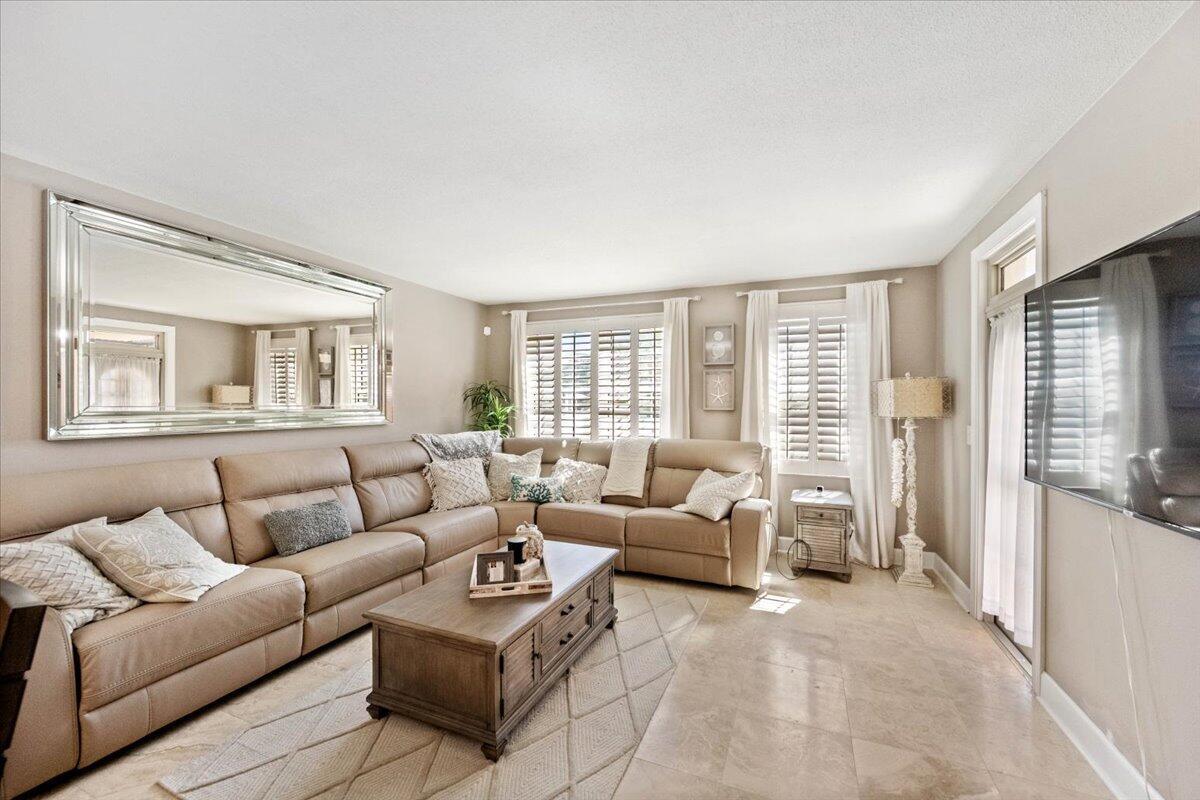 A living room features a large beige sectional sofa, a coffee table, and a mirror — 3475 S Ocean Boulevard # 1030, Palm Beach FL 33480, PALM BEACH, FL