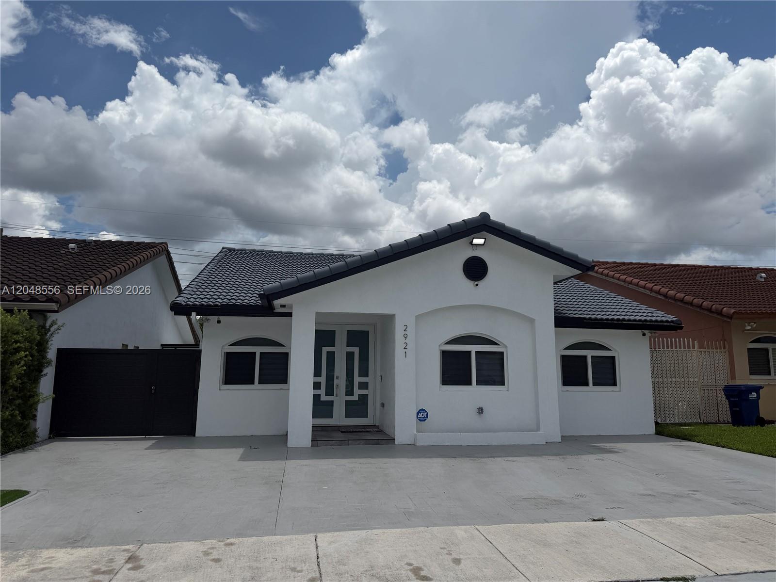 A white single-story house with a dark tiled roof and a concrete driveway — 2921 SW 136th Ct, Miami FL 33175, MIAMI, FL