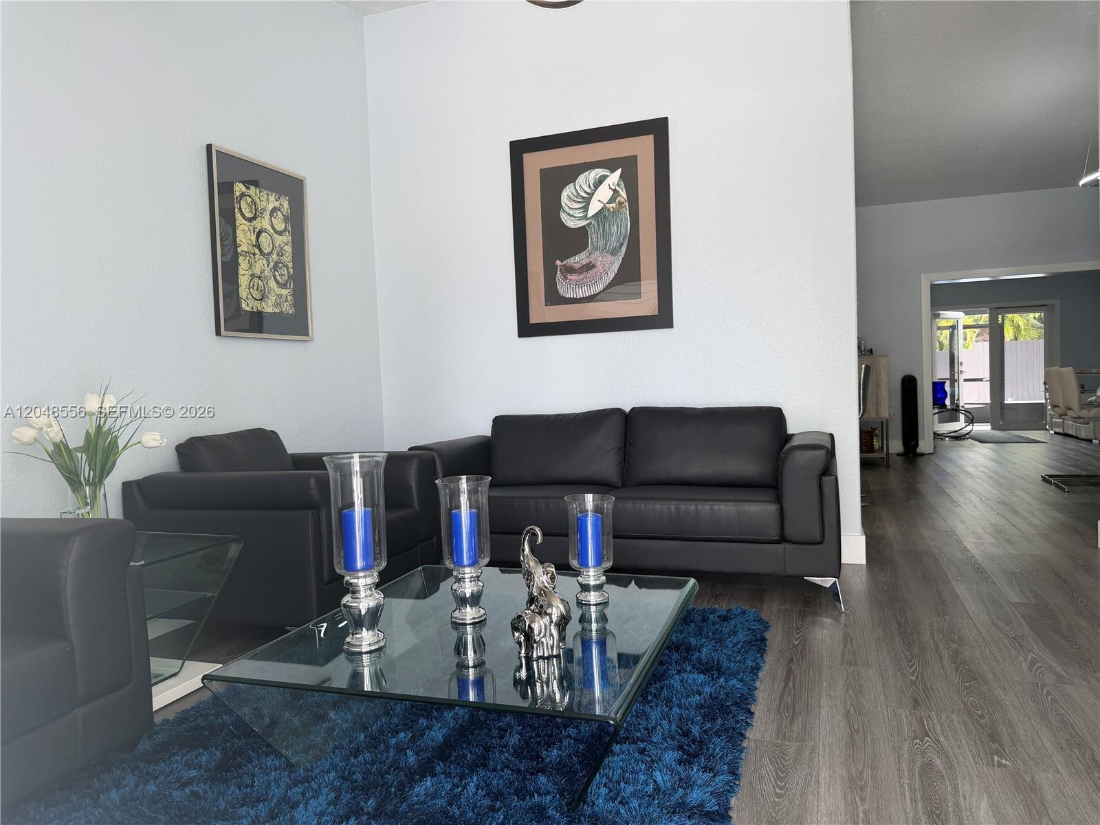 A living room features black leather furniture, a glass coffee table, and a blue rug — 2921 SW 136th Ct, Miami FL 33175, MIAMI, FL