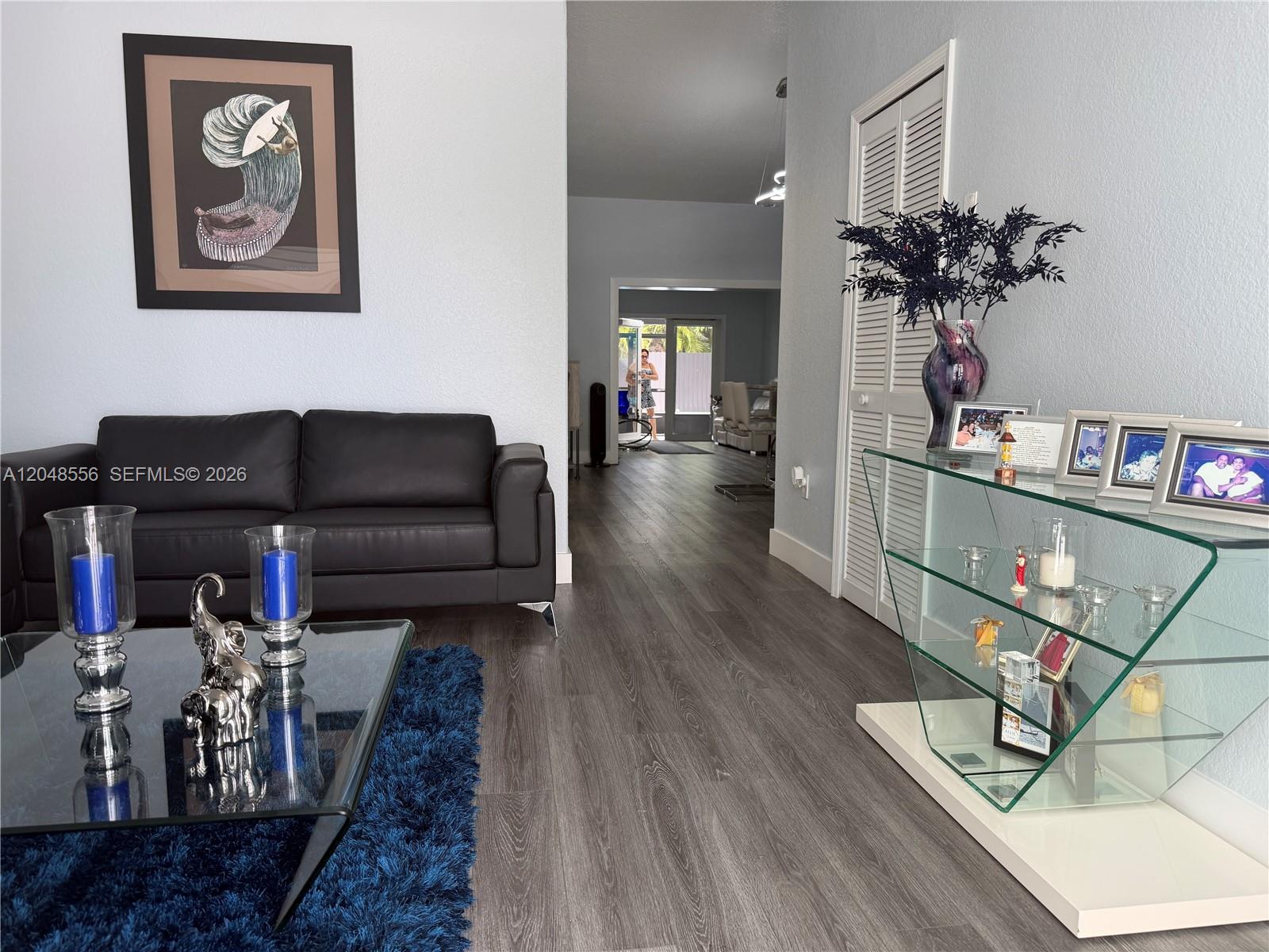 A living room features a black sofa, glass coffee table, and a glass display shelf — 2921 SW 136th Ct, Miami FL 33175, MIAMI, FL