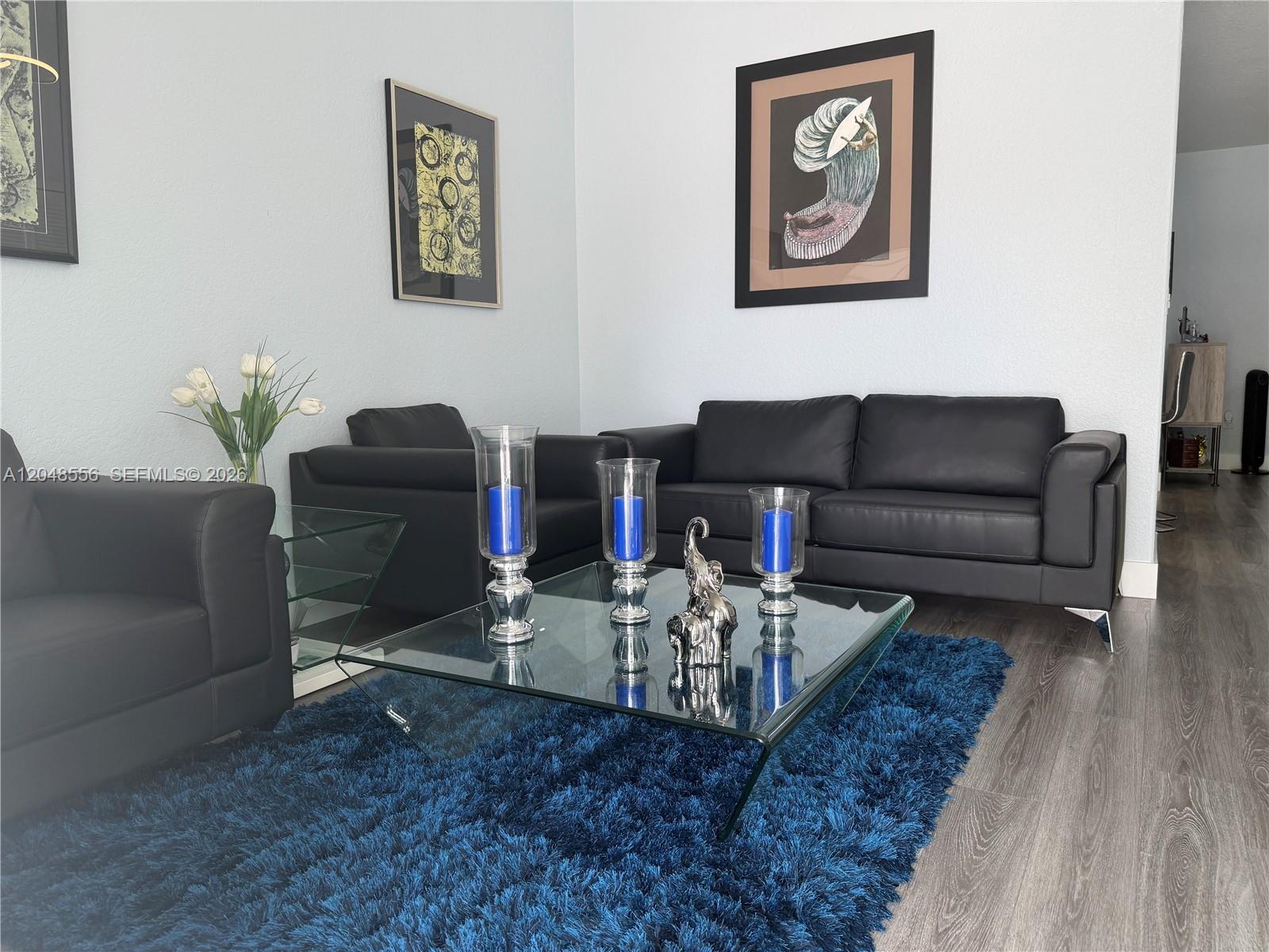 A living room features black leather sofas, a glass coffee table, and a blue rug — 2921 SW 136th Ct, Miami FL 33175, MIAMI, FL