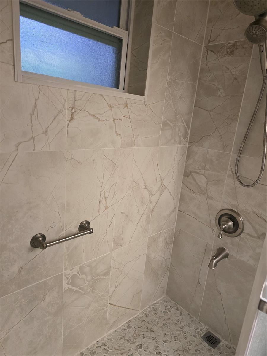 A tiled shower stall features a grab bar, a handheld showerhead, and a window — 12730 SW 112th Street, Miami FL 33186, MIAMI, FL