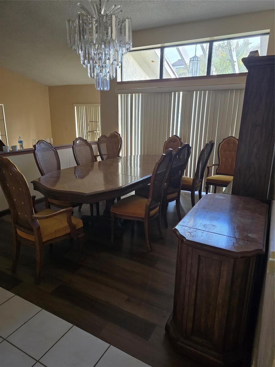 A dining room features a large wooden table, eight chairs, and a crystal chandelier — 12730 SW 112th Street, Miami FL 33186, MIAMI, FL