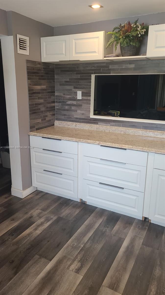A kitchen features white cabinets, a speckled countertop, and a gray horizontal tile backsplash — 1402 NW 80th Ave # 205, Margate FL 33063, MARGATE, FL