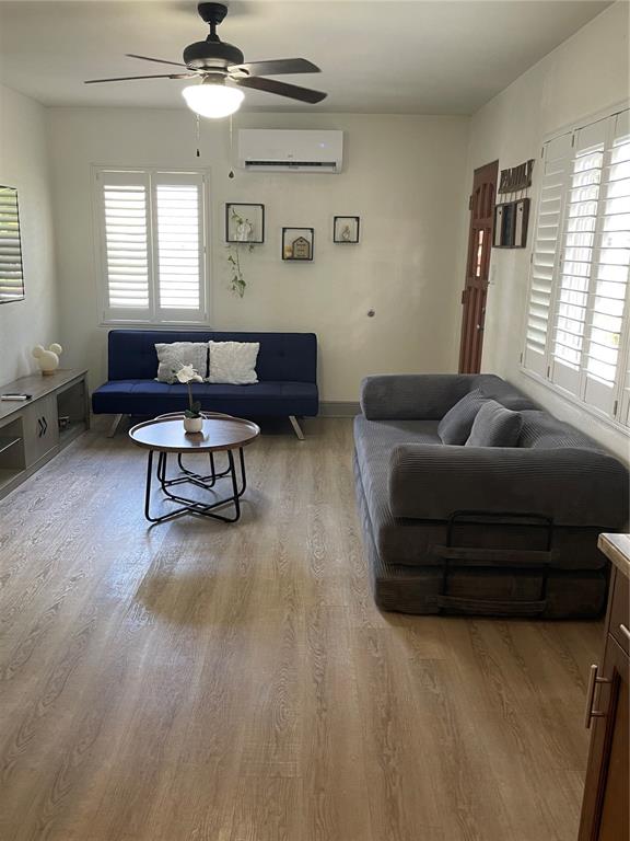 A living room features light wood-look flooring, a ceiling fan, and two sofas — 2829 21ST STREET N, ST PETERSBURG, FL