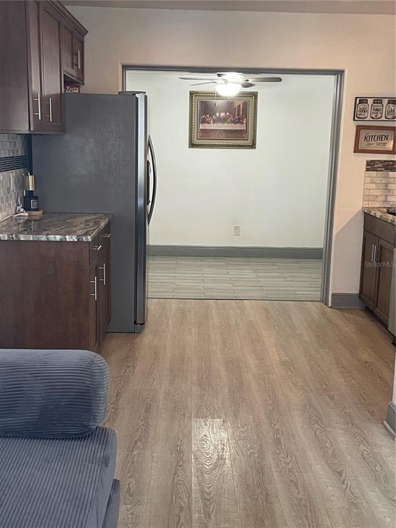 A kitchen with dark wood cabinets and a refrigerator opens into a dining area — 2829 21ST STREET N, ST PETERSBURG, FL