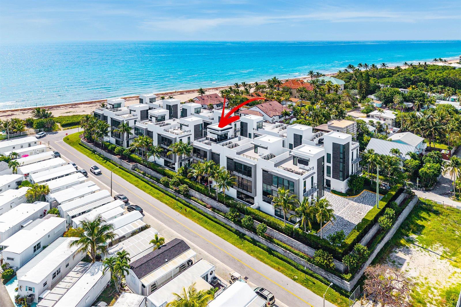 An aerial view shows a modern white multi-unit residential complex near a sandy beach — 11501 Old Ocean Boulevard, Ocean Ridge FL 33435, OCEAN RIDGE, FL