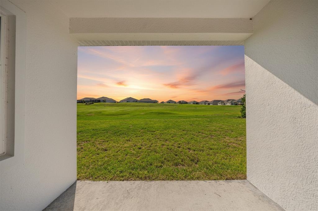 A view of a grassy field and distant houses from a covered concrete patio — 4816 N CRESTLINE DRIVE, BEVERLY HILLS, FL