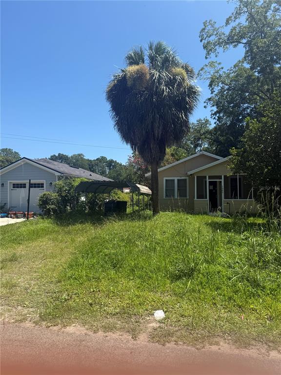 A single-story house with a palm tree and a detached garage in a grassy yard — 5905 BRILEY AVENUE, JACKSONVILLE, FL