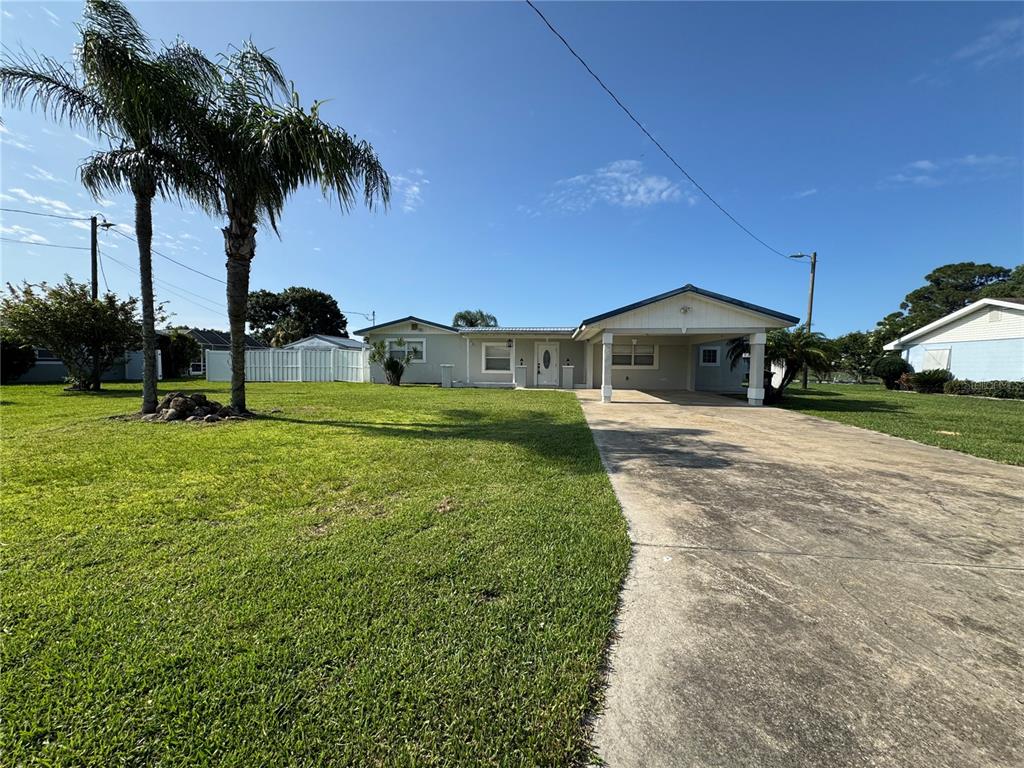 A single-story house with a carport, a concrete driveway, and two palm trees in front — 502 CANAL DRIVE, LAKE WALES, FL