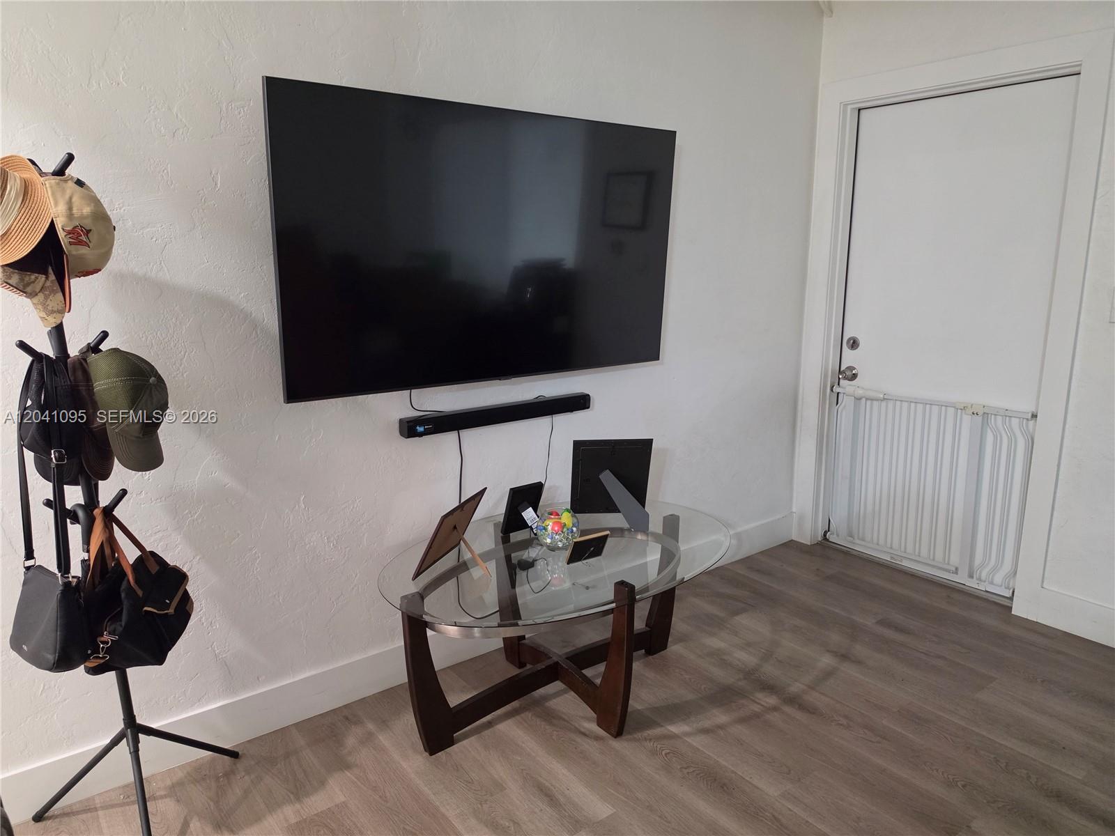 A wall-mounted television and soundbar are positioned above a glass-topped table in a room — 711 Beacom Blvd # 4, Miami FL 33135, MIAMI, FL