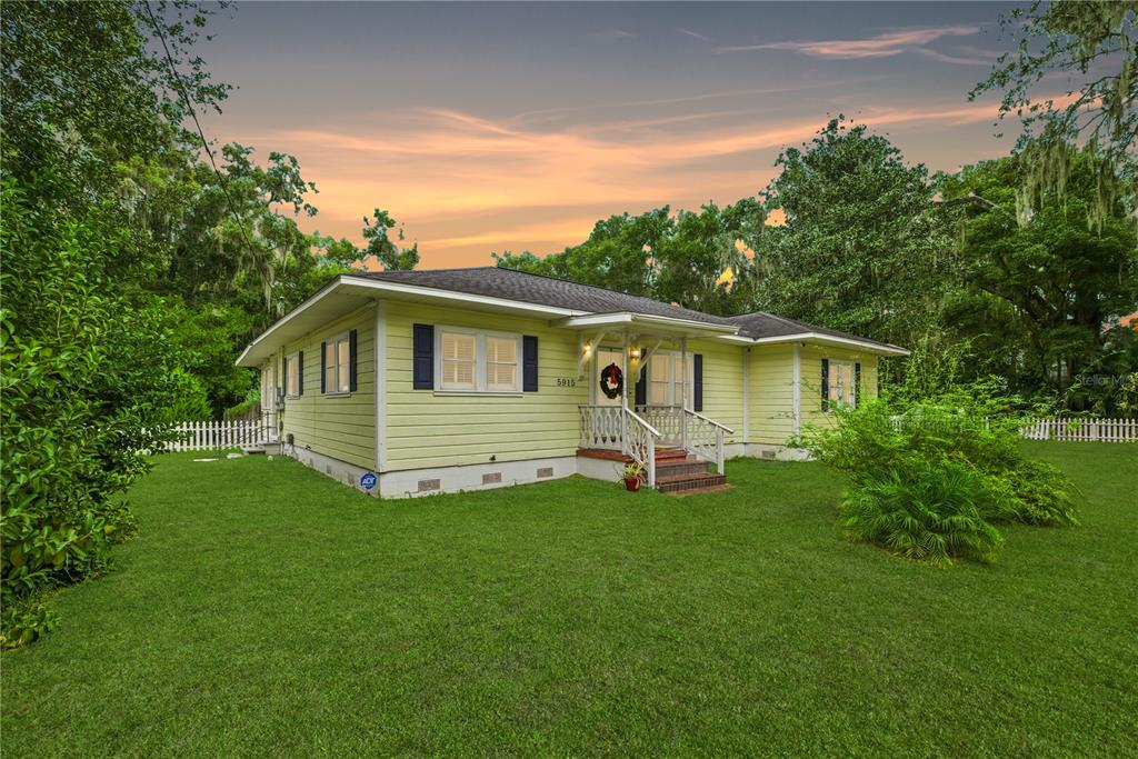 A light yellow, single-story house with a front porch sits on a grassy lawn — 5915 AVENUE F, MC INTOSH, FL
