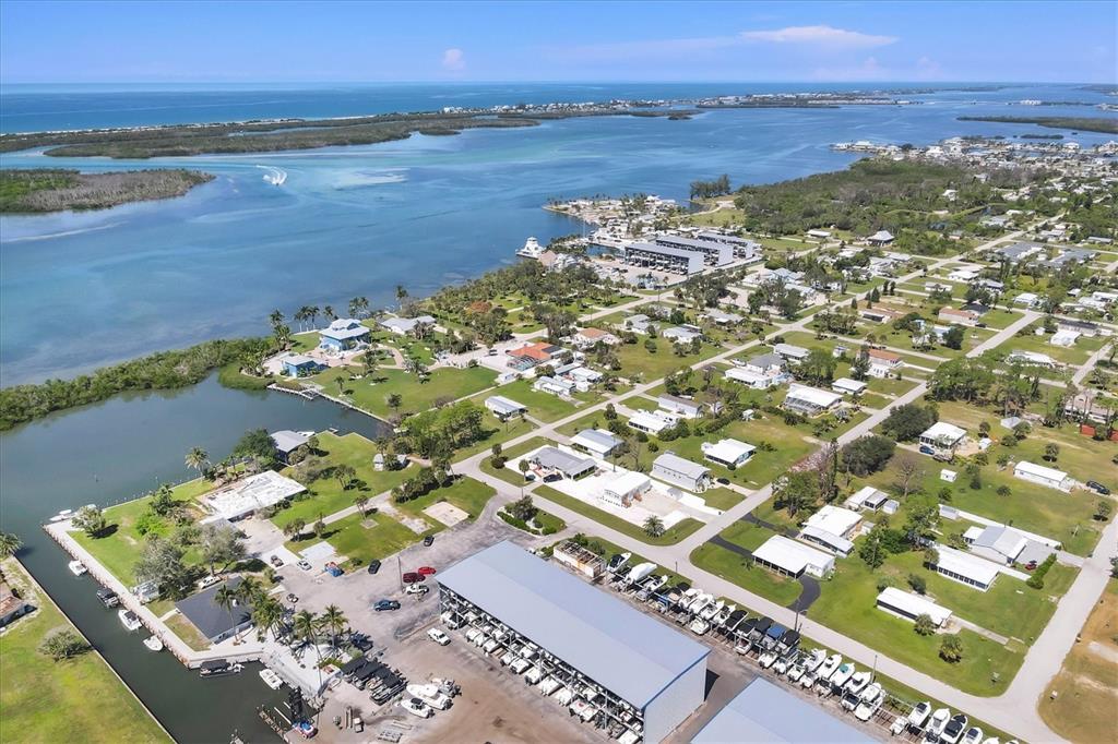 An aerial view shows a coastal neighborhood with a boat storage facility and waterfront homes — 3280 HOLLY AVENUE, ENGLEWOOD, FL