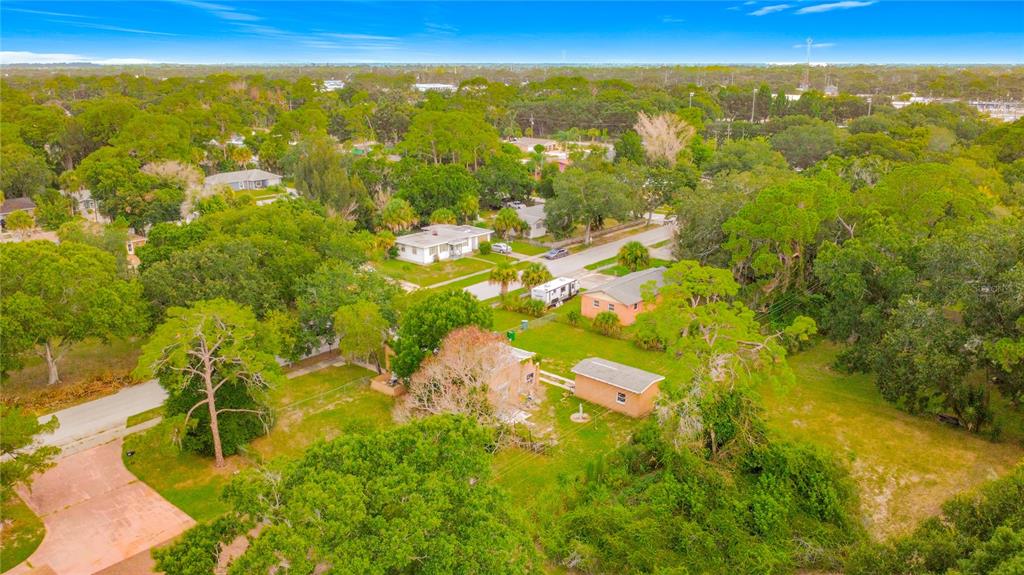 An aerial view of a residential property featuring a house, a shed, and surrounding trees — 618 S VARR AVENUE, COCOA, FL