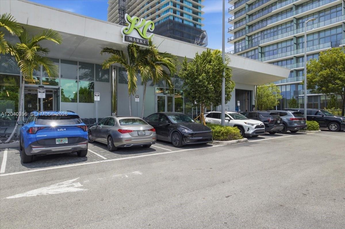 A blue Kia SUV and several other cars are parked in front of a market — 1002 E Hallandale Beach Blvd # 101, Hallandale Beach FL 33009, HALLANDALE BEACH, FL