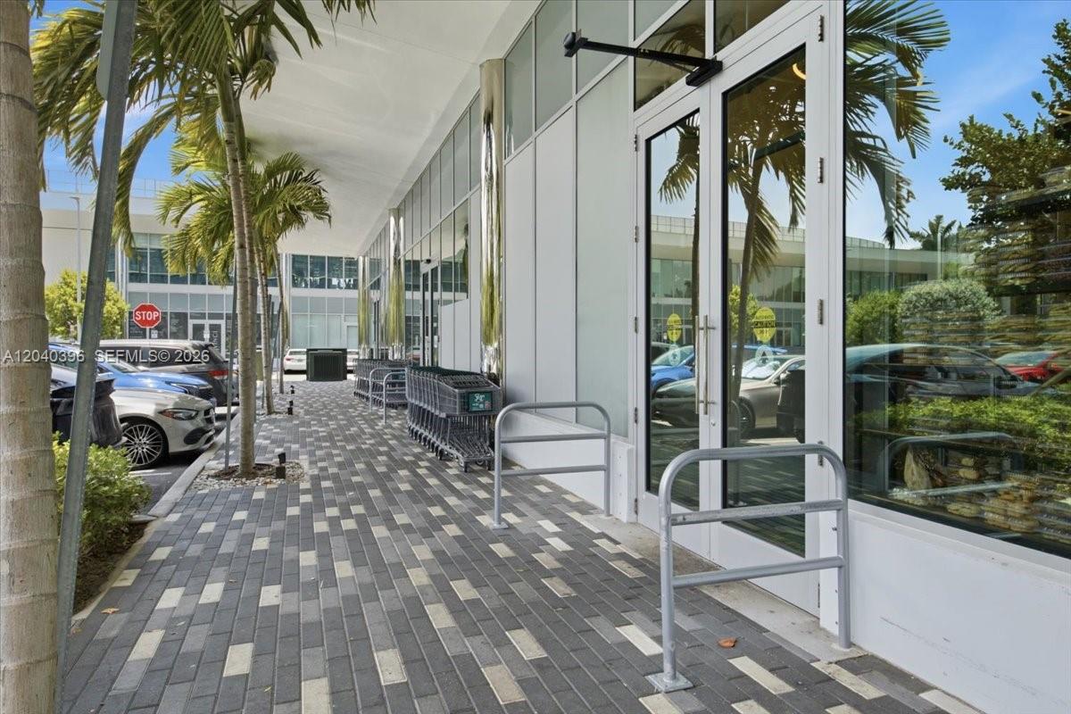 A paved walkway leads past a glass storefront entrance with a row of shopping carts — 1002 E Hallandale Beach Blvd # 101, Hallandale Beach FL 33009, HALLANDALE BEACH, FL