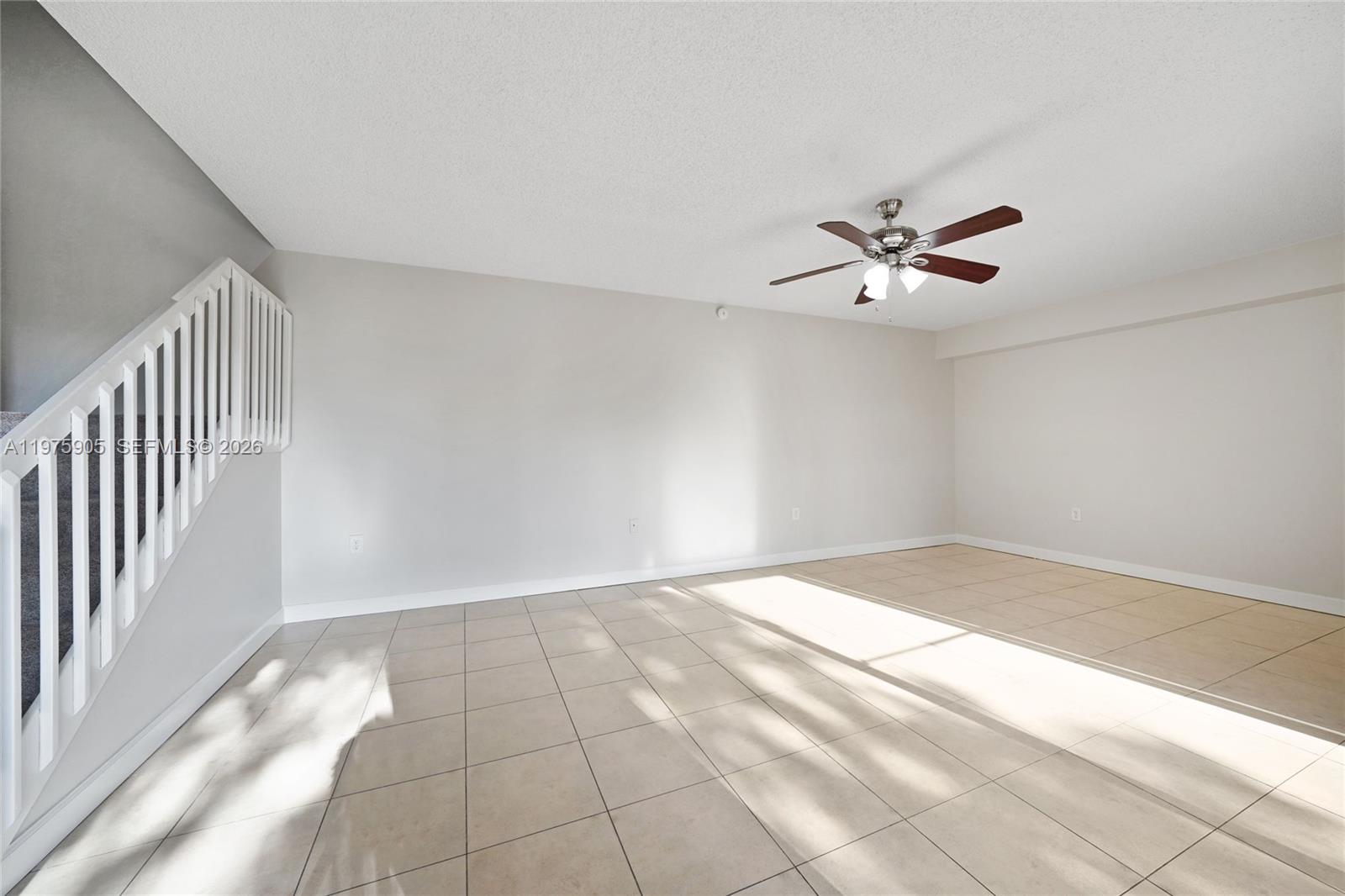 An empty room features light-colored tile flooring, white walls, and a ceiling fan — 2206 22nd Way, West Palm Beach FL 33407, WEST PALM BEACH, FL