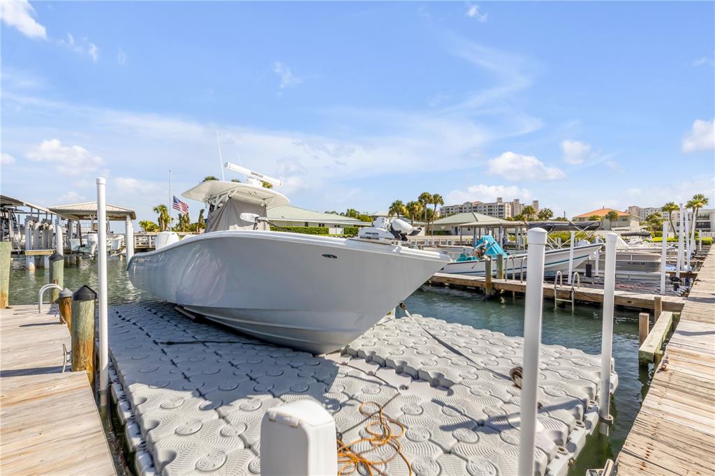 A white center console boat is docked on a floating platform at a marina — 2100 N PENINSULA AVENUE UNIT 305, NEW SMYRNA BEACH, FL