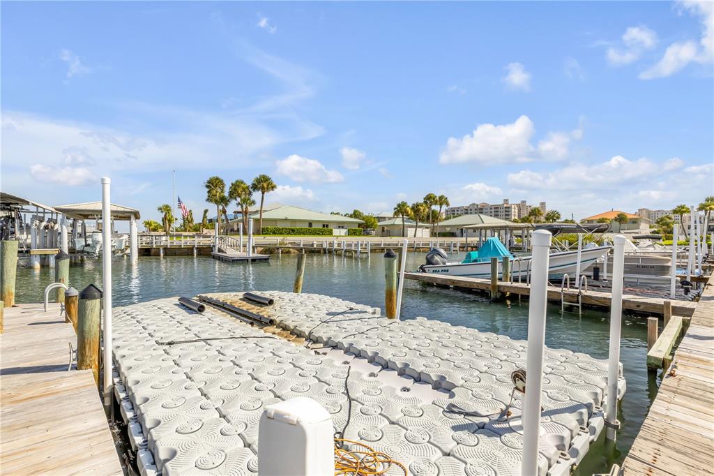 A floating dock sits in a canal with boats moored at nearby slips — 2100 N PENINSULA AVENUE UNIT 305, NEW SMYRNA BEACH, FL