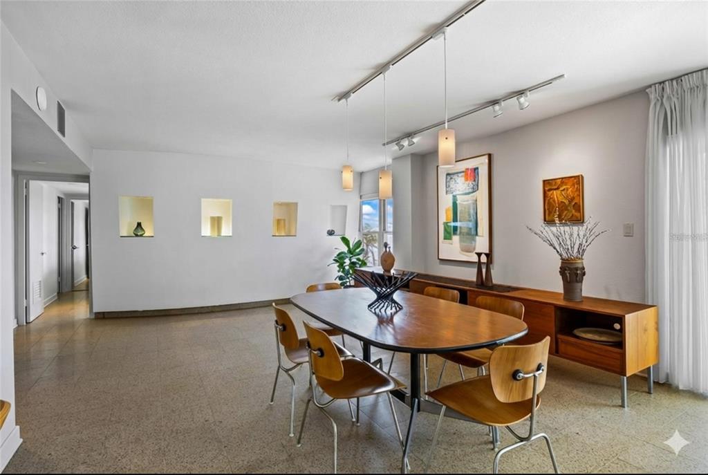 A dining room features a wooden table, mid-century modern chairs, and recessed wall niches — 2401 BAYSHORE BOULEVARD UNIT 410, TAMPA, FL