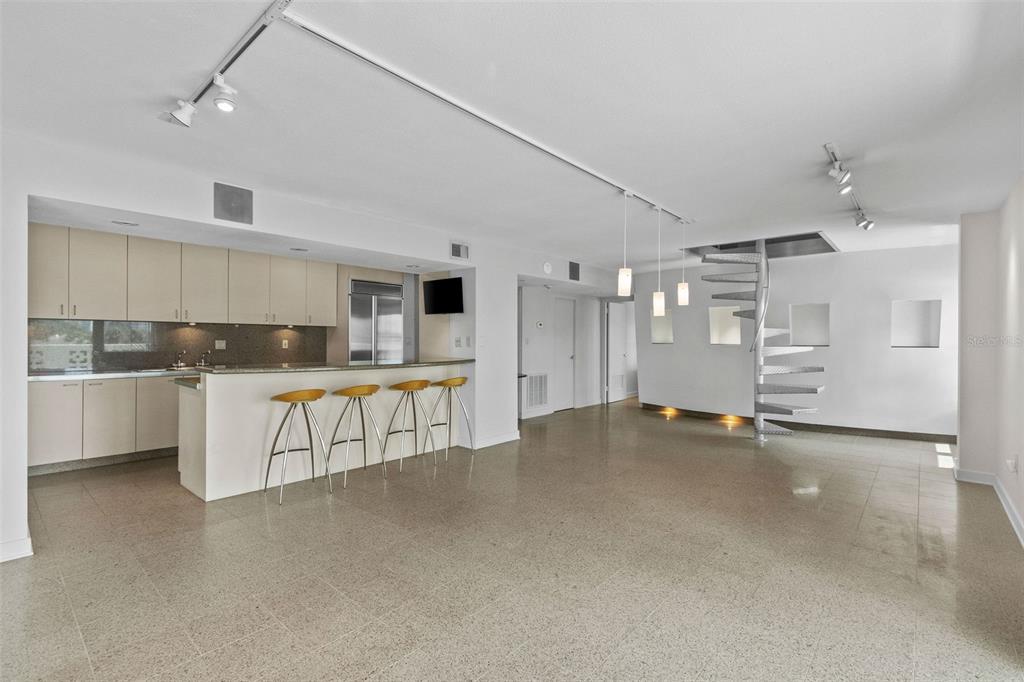 A modern kitchen with light cabinetry and a breakfast bar opens into a spacious living area — 2401 BAYSHORE BOULEVARD UNIT 410, TAMPA, FL