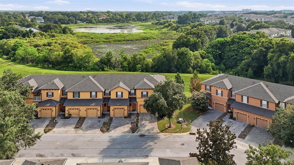 An aerial view shows two multi-story townhome buildings with garages facing a paved street — 1610 RETREAT VIEW CIRCLE, SANFORD, FL