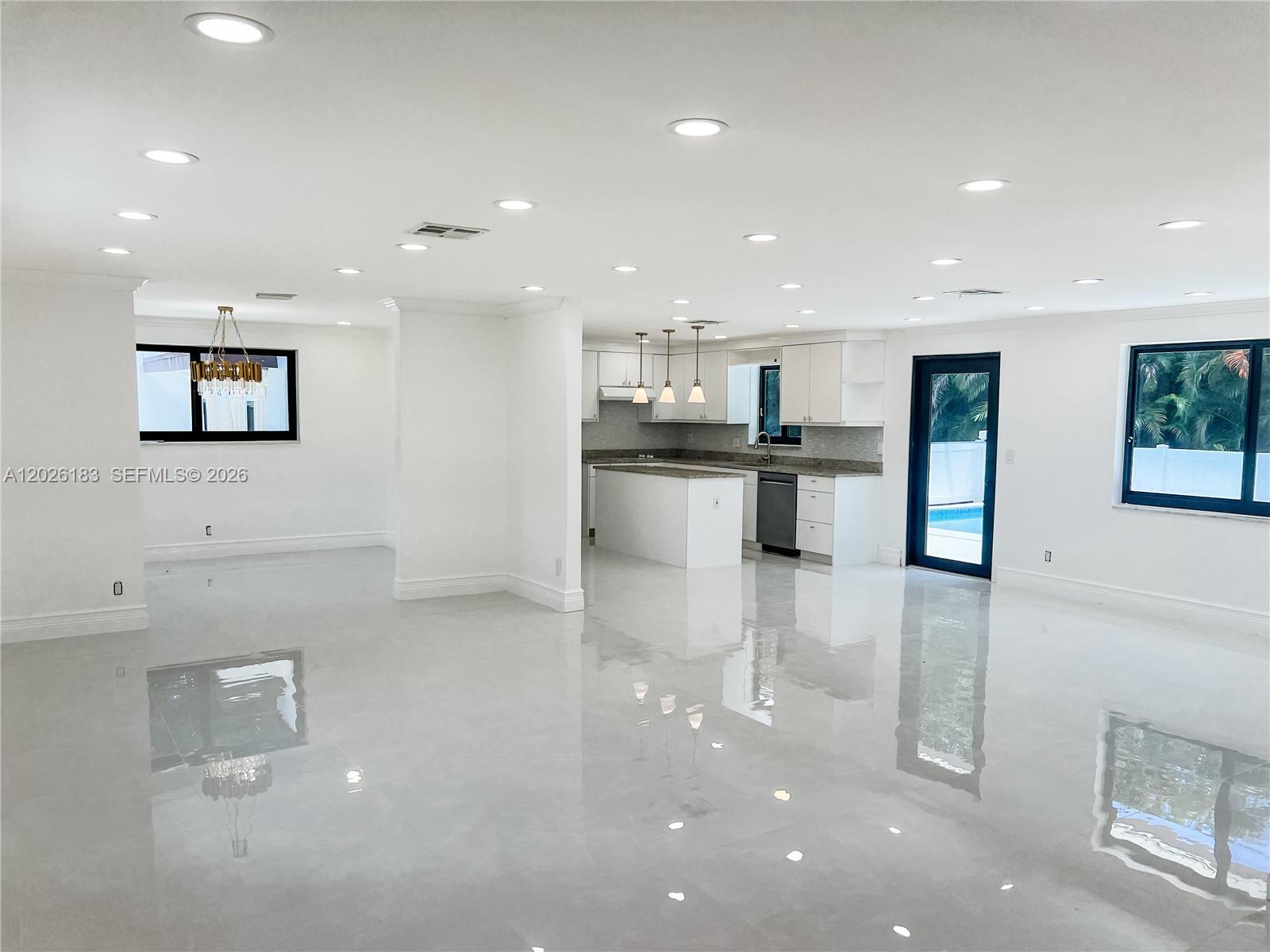 An open-concept living area features a kitchen with white cabinetry and glossy tile flooring — 12200 NW 20th Ct, Plantation FL 33323, PLANTATION, FL