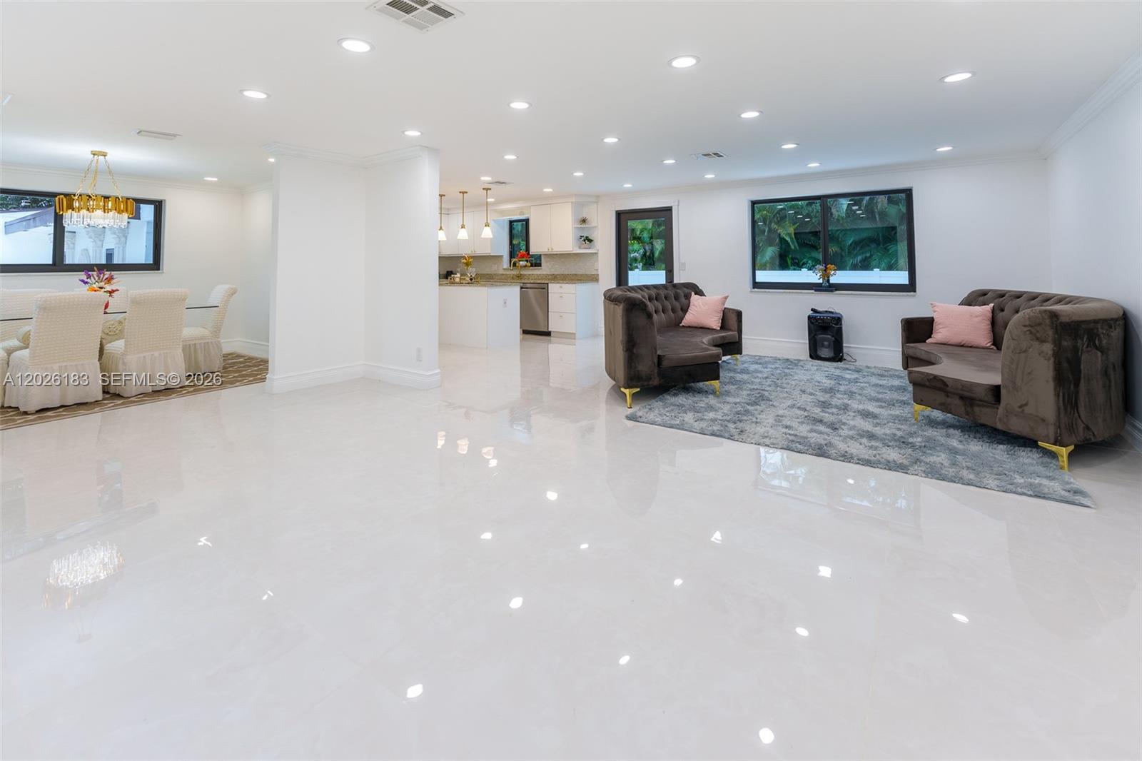An open-concept living and dining area features white tile floors, recessed lighting, and dark furniture — 12200 NW 20th Ct, Plantation FL 33323, PLANTATION, FL